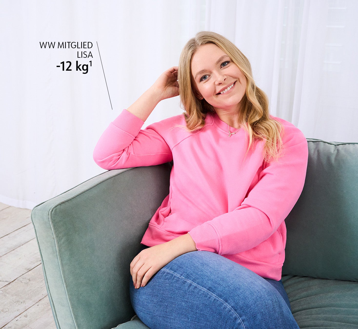 WW member Lisa in pink sweater sits on sofa