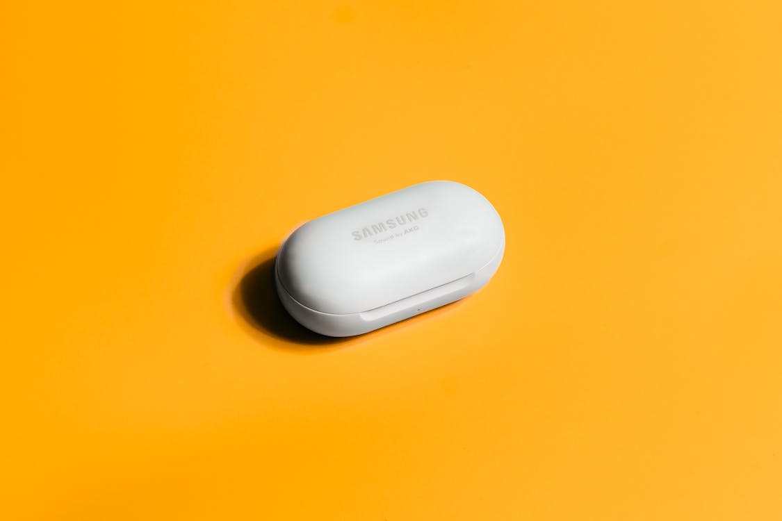 Free A Samsung Galaxy Buds on a Yellow Surface Stock Photo