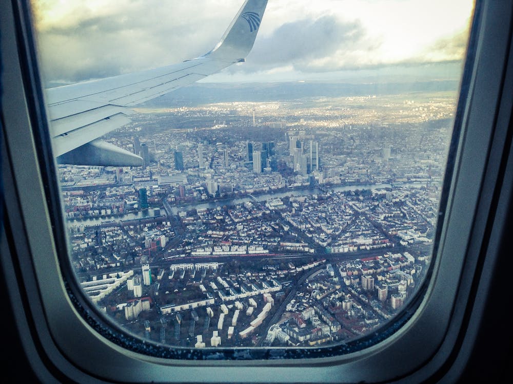 Free Airplane Windowpane Showing City Buildings Stock Photo