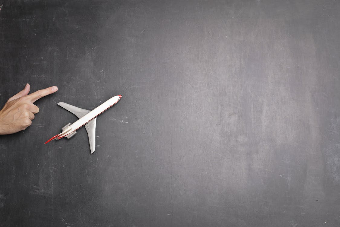 Free Toy plane and human hand on chalkboard Stock Photo