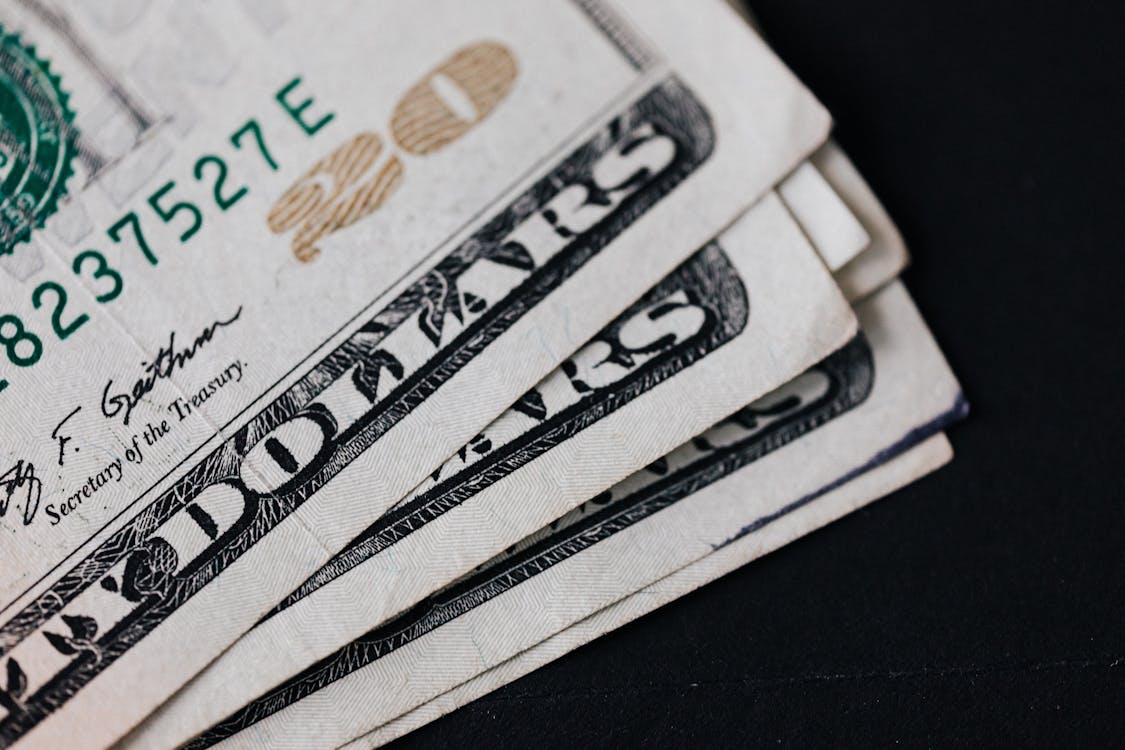Free Pile of American paper money on black surface Stock Photo