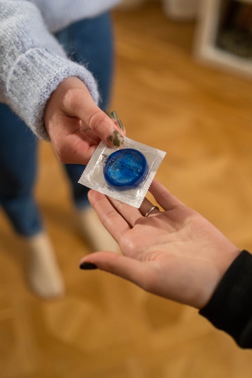 Free Handing Out Blue Condom Stock Photo