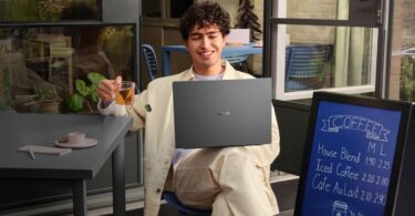 Persona che lavora in un cafe con ASUS Vivobook S16 grigio