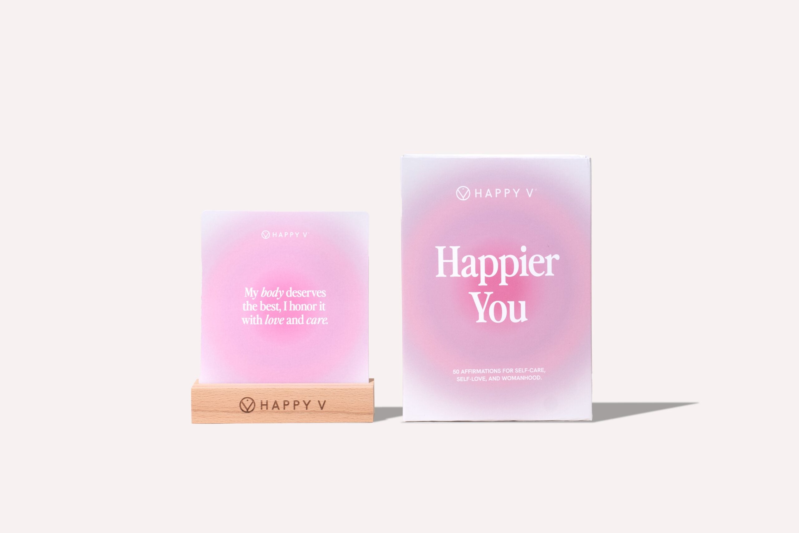 Happy V affirmation cards in a wooden holder beside the box