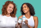 Two women holding Happy V wellness products in a bright lifestyle scene