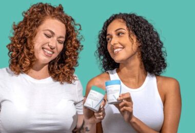 Two women holding Happy V wellness products in a bright lifestyle scene