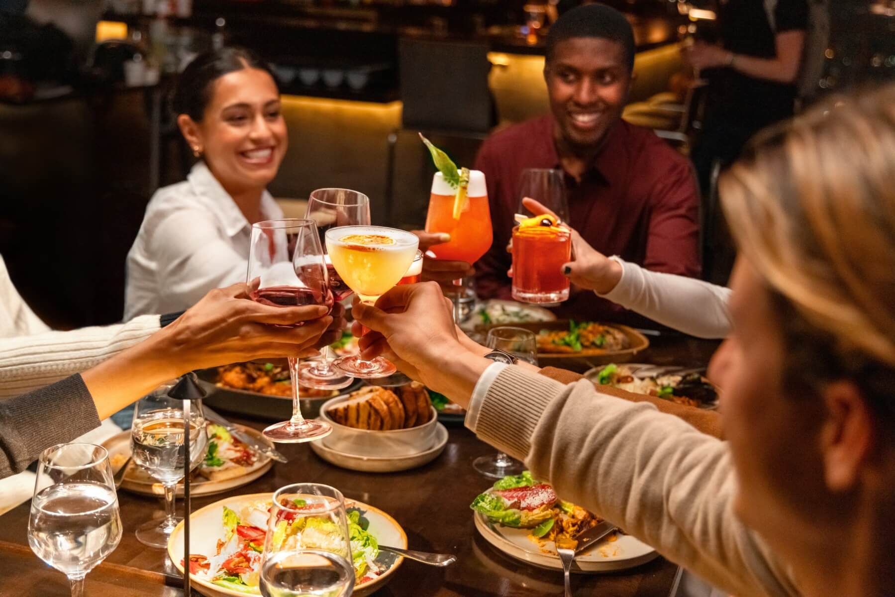 Convives levant leurs verres au restaurant ONE Dine