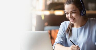 Woman wearing a headset at a laptop during online training