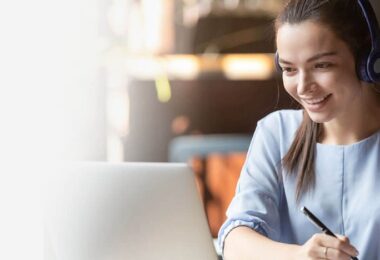 Woman wearing a headset at a laptop during online training