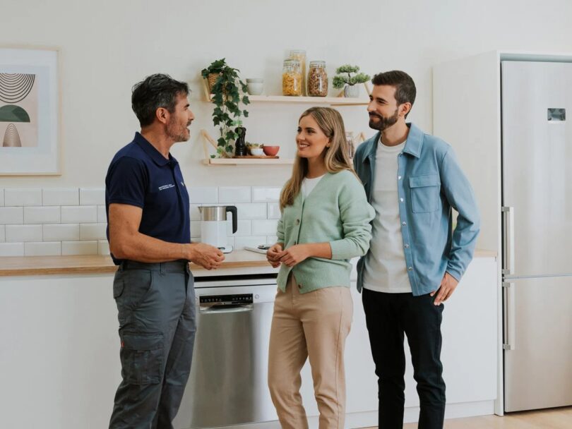 Pareja consultando a un técnico en una cocina con electrodomésticos Bosch
