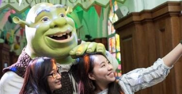 Visitors posing with Shrek at Shrek's Adventure in London