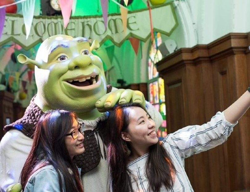 Visitors posing with Shrek at Shrek's Adventure in London