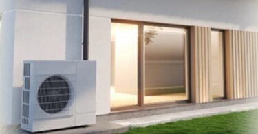 Unità esterna di una pompa di calore accanto a una casa