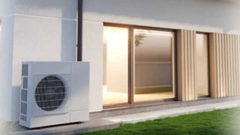 Unità esterna di una pompa di calore accanto a una casa