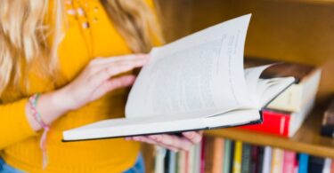 Uczeń czyta książkę przy stole w domowym wnętrzu