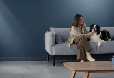 Mujer con perro en un sofá, escena de hogar