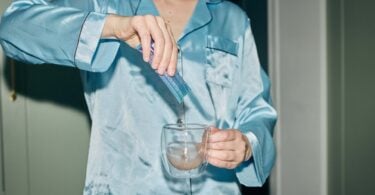 Person pouring an Astro Dust drink into a glass mug