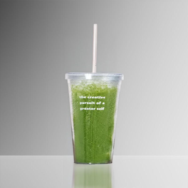 Green drink in a clear plastic cup with a straw