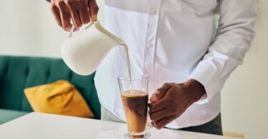 Milk being poured into a glass drink